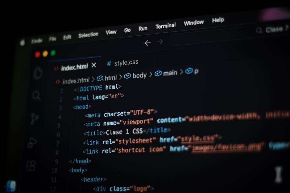 A close-up view of a computer screen displaying HTML code in a dark mode editor. The code includes tags such as <!DOCTYPE html>, <html>, <head>, <title>, and <link>, with syntax highlighting in blue, 